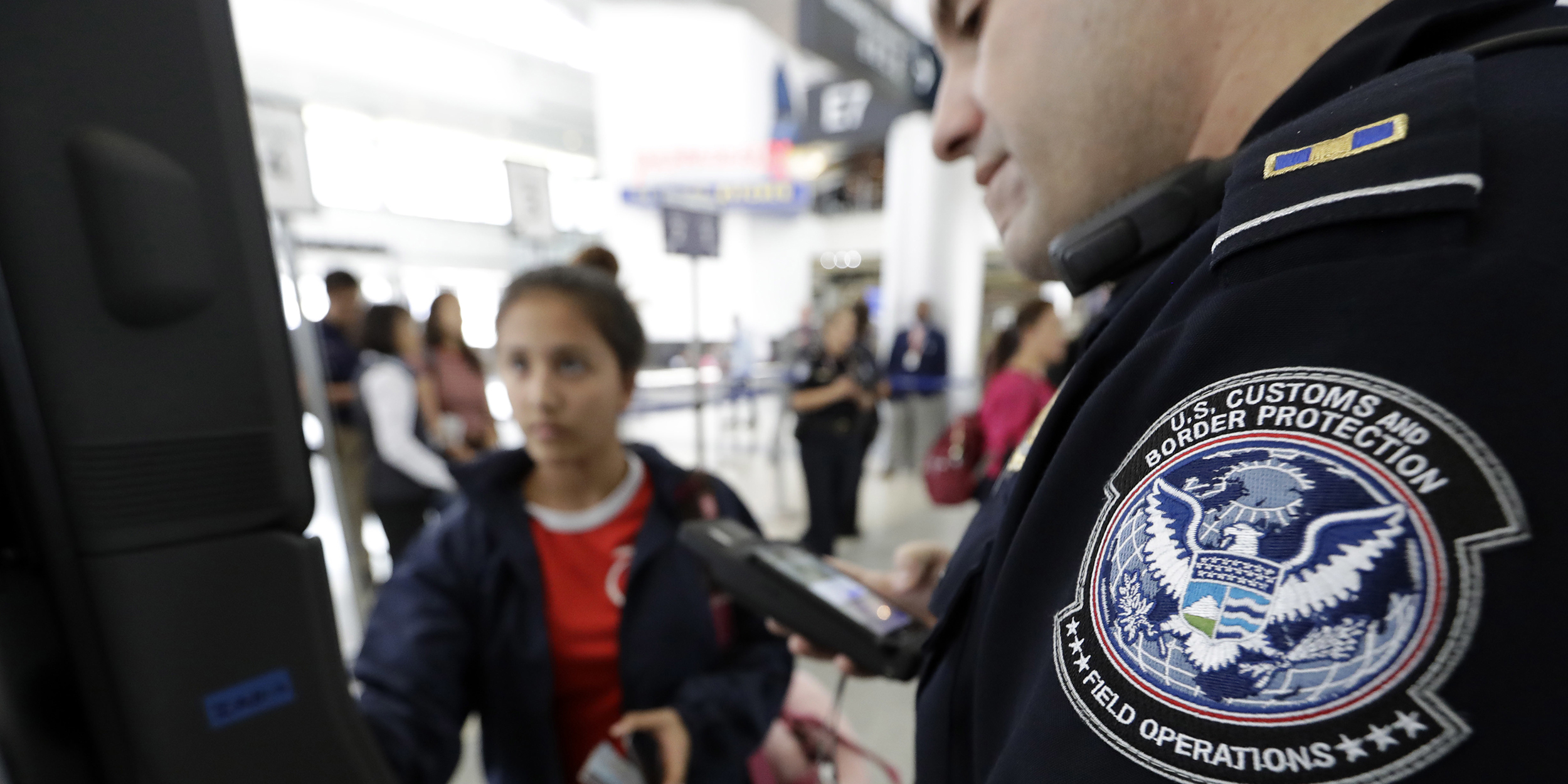 U.S. Customs and Border Protection officer Julio Corro, right, helps a passenger navigate one of the new facial recognition kiosks at a United Airlines gate before boarding a flight to Tokyo, Wednesday, July 12, 2017, at George Bush Intercontinental Airport, in Houston. The Trump administration intends to require that American citizens boarding international flights submit to face scans, something Congress has not explicitly approved and privacy advocates consider an ill-advised step toward a surveillance state. (AP Photo/David J. Phillip)