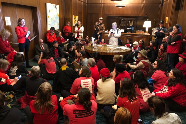 FILE - In this Nov. 21, 2019, file photo, demonstrators against a proposed liquid-natural gas pipeline and export terminal in Oregon sit in in the governor's office in the State Capitol in Salem, Ore., to demand Democratic Gov. Kate Brown stand against the proposal. The Jordan Cove pipeline is undergoing a permitting process and would end at a proposed marine export terminal in Coos Bay, Ore. Members of a federal regulatory agency on Thursday, Feb. 20, 2020, delayed a vote on the project, with one member saying greenhouse gas emissions and endangered species should be considered. (AP Photo/Andrew Selsky, File)