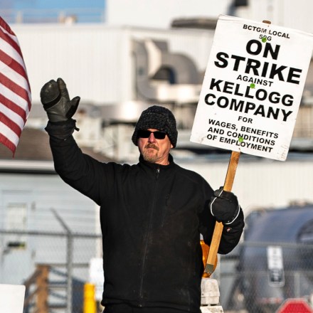 Kirk Peters waves to passing cars as they honk in support of Kellogg's workers on strike along I Street in Omaha, Neb. on Tuesday, Dec. 7, 2021.