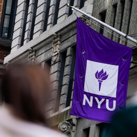 FILE - People wait in line at a COVID-19 testing site near the New York University campus in New York, on Dec. 16, 2021. Ten years after receiving it, NYU publicized on Wednesday, Dec. 14, 2022, a $100 million gift from the hedge fund leader John Paulson, who made a fortune shorting the subprime housing crisis, to support the construction of a now mostly-complete building that will also be named after him. (AP Photo/Seth Wenig, File)