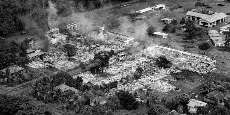 A section of the rubber plantation town of Snoul, Cambodia, smolders in early May 1970, after nearly 90 percent of the town was destroyed in air strikes and heavy fighting between U.S. forces and North Vietnamese troops. By May 6, the U.S. 11th Armored Cavalry Regiment occupied the town. (AP Photo/Henri Huet)